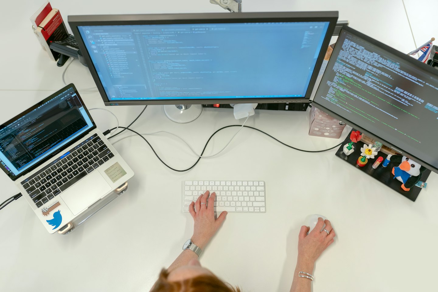 Entwickler programmiert an einem Arbeitsplatz mit mehreren Monitoren im Büro.
