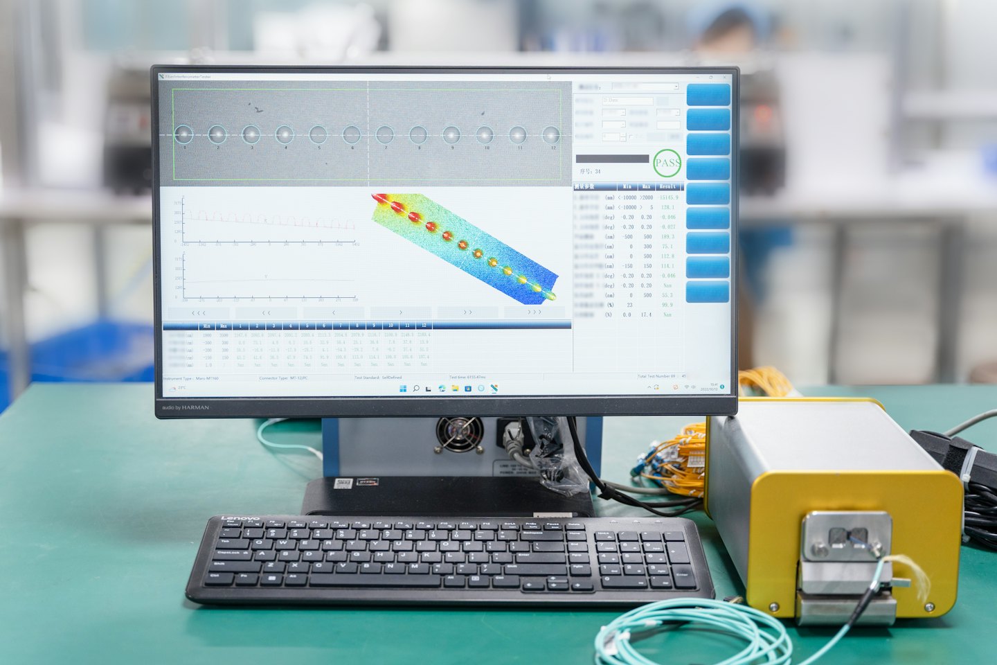 Ein Computermonitor zeigt technische Diagramme, die mit Industriemaschinen auf einer Werkbank verbunden sind.